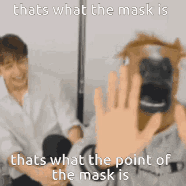 a person taking a picture of another person with a mask on their face .