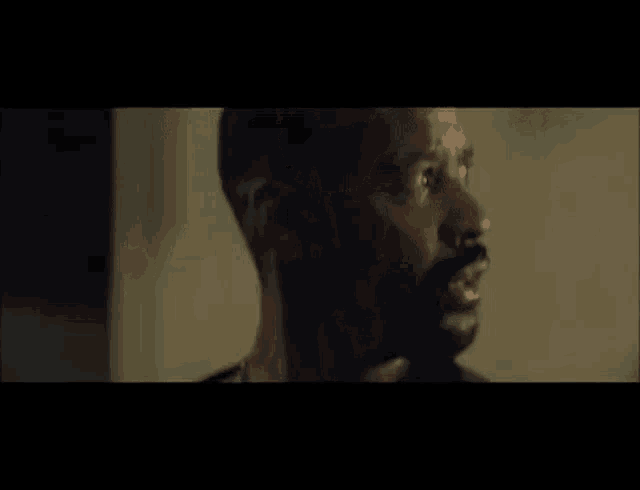 a man with a beard is screaming with his mouth open in a close up of his face .