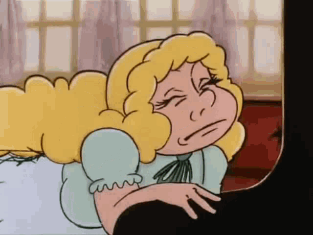 a cartoon girl is laying on a bed with her eyes closed .