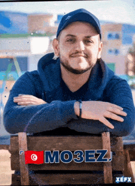 a man with a beard is sitting on a wooden crate with the name mozez