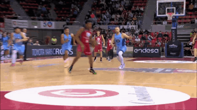a basketball game is being played on a court with toyota and endesa advertisements on the sidelines