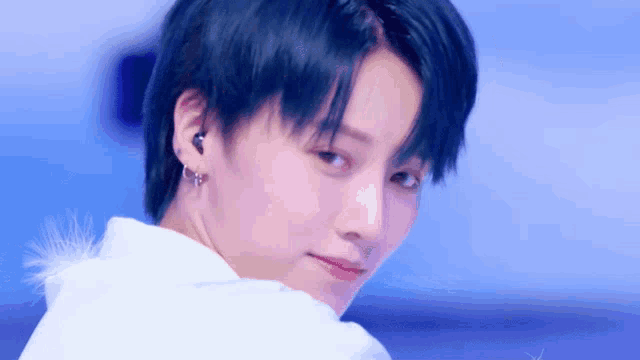 a close up of a person with blue hair and earrings
