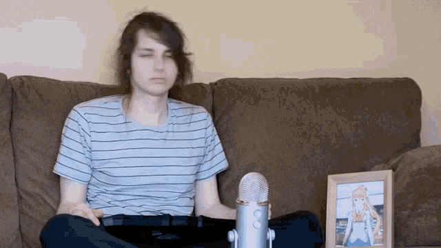 a man sits on a couch next to a picture of a girl