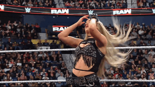 a woman in a wrestling ring is wearing a black top that says dirty