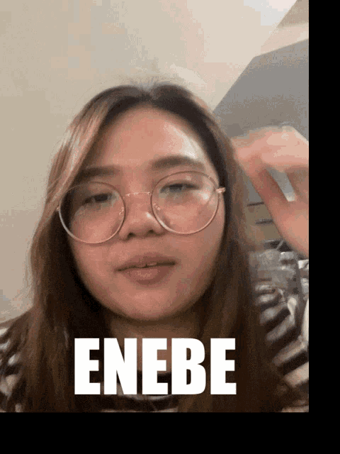 a woman wearing glasses with the word enebe written on her face