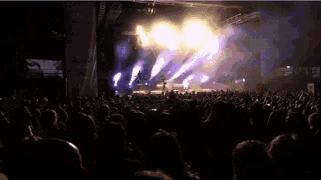 a crowd of people watching a concert with a sign on the wall that says ' nbc '