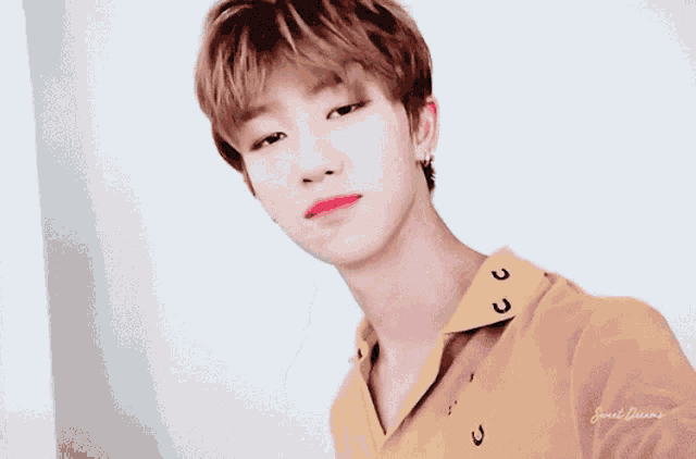 a young man wearing a yellow shirt that says sweet queen