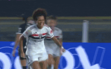 a female soccer player is celebrating a goal with her teammates on the field .