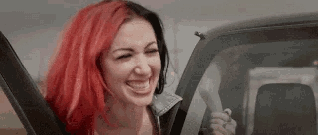 a woman with red hair is sitting in a car .