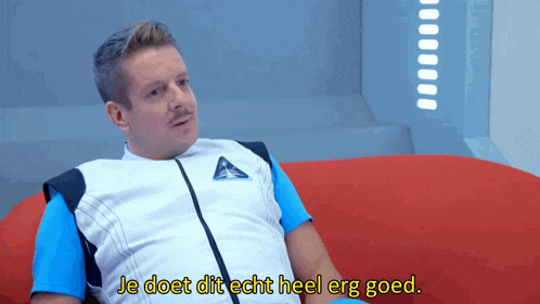 a man is sitting on a red couch and the words je doet dit echt heel erg goed are above him