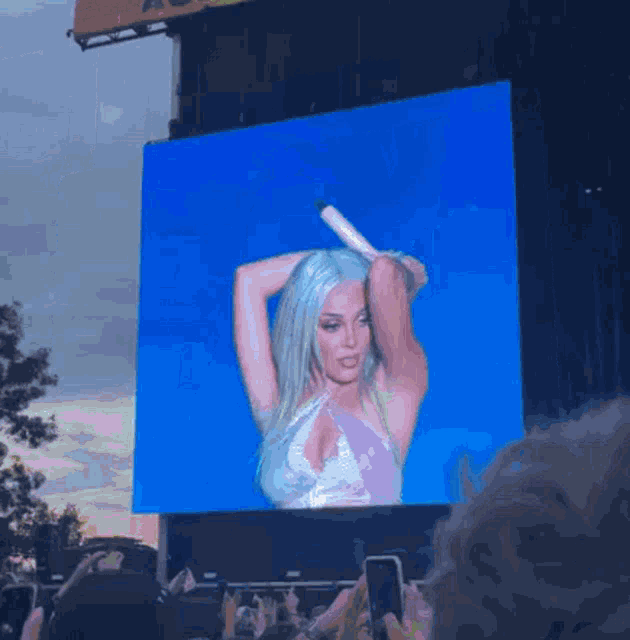 a large screen displays a woman holding a microphone