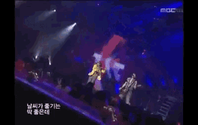 a man singing into a microphone while playing a guitar in front of a crowd at a concert sponsored by mbc