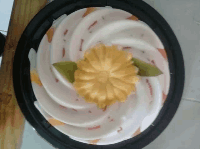 a cake with a flower on top of it in a plastic container
