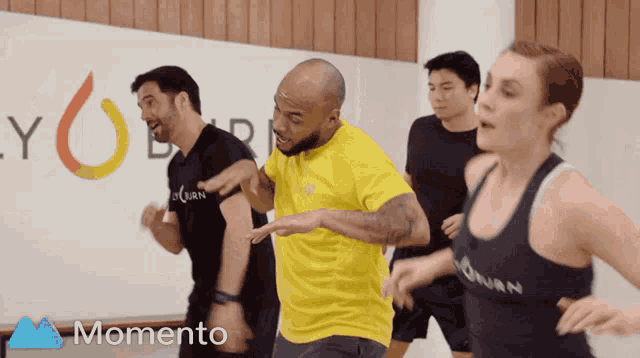 a group of people are dancing in front of a momento ad