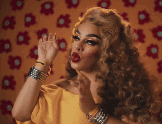a woman wearing a yellow top and red lipstick is making a funny face