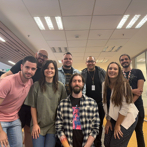 a group of people posing for a picture including a man wearing a plaid shirt