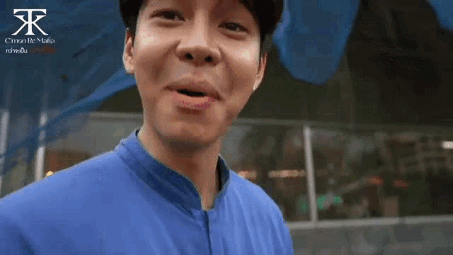 a man wearing a blue shirt with a foreign language on it
