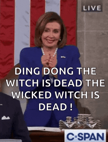 a woman in a blue suit says ding dong the witch is dead