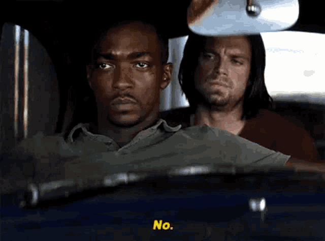 a man is driving a car with another man in the back seat .