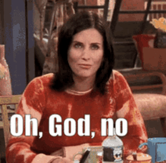 a woman in a red sweater is sitting at a table with the words oh god no written above her