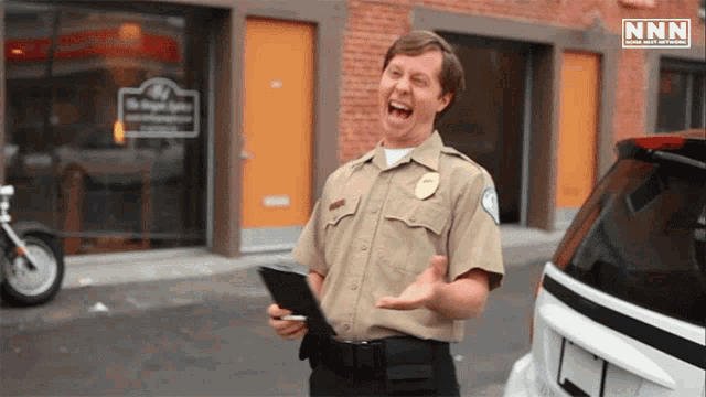 a police officer laughs in front of a building that says nnn on it