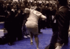 a woman in a white dress is running in front of a crowd