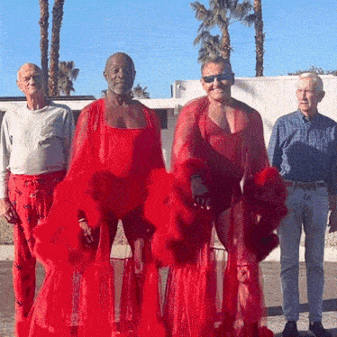 a group of men are standing next to each other wearing red clothes