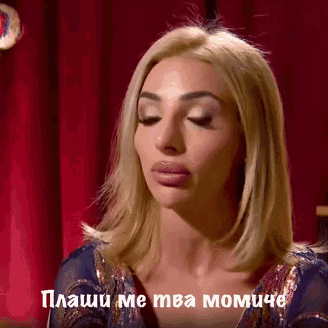 a blonde woman with a red curtain behind her and the words " plashi me tma momiche " on the bottom