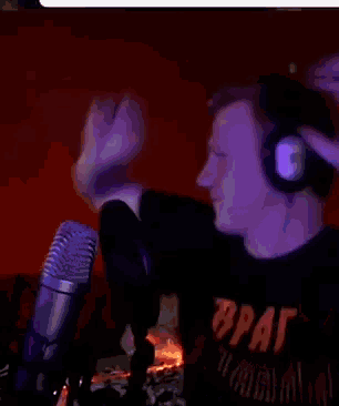 a man wearing headphones and a black shirt that says brat