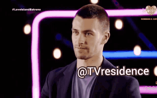 a man in a suit is standing in front of a screen that says @tvresidence on it