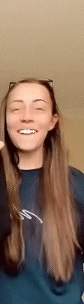a woman with long hair is wearing sunglasses and a blue shirt and smiling .