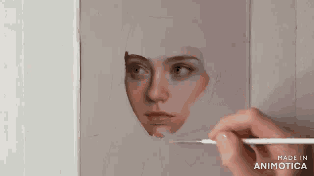 a person is painting a woman 's face with a brush and the words made in animotica are on the bottom