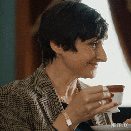 a woman drinking a cup of tea from a netflix advertisement