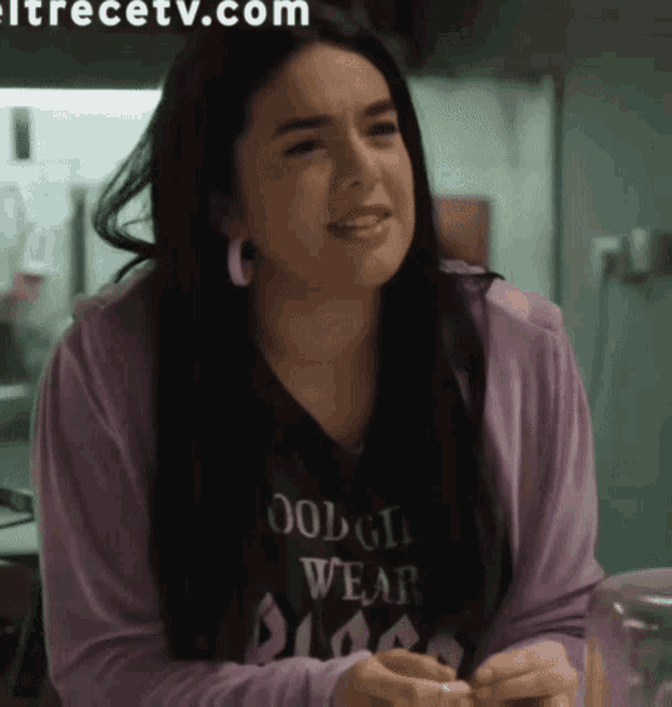 a woman wearing a black shirt that says " good girls wear pink "