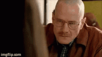 a man wearing glasses is looking at a computer screen .