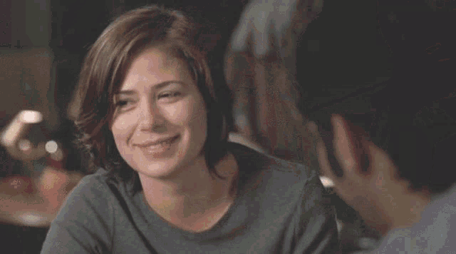 a woman is smiling and looking at a man