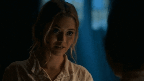 a woman in a white shirt is talking to another woman in a dark room and says " your power "