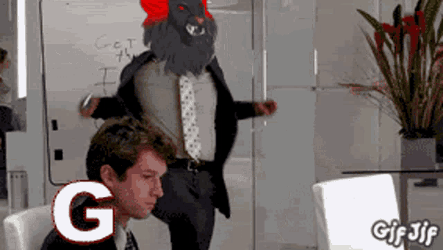 a gif of a man in a suit and tie with a lion on his head