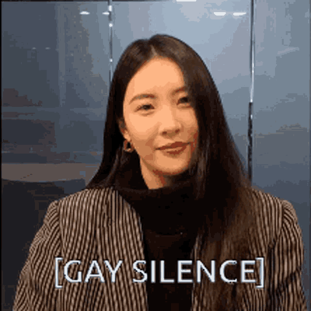 a woman with long hair is wearing a striped jacket and a black turtleneck and says gay silence