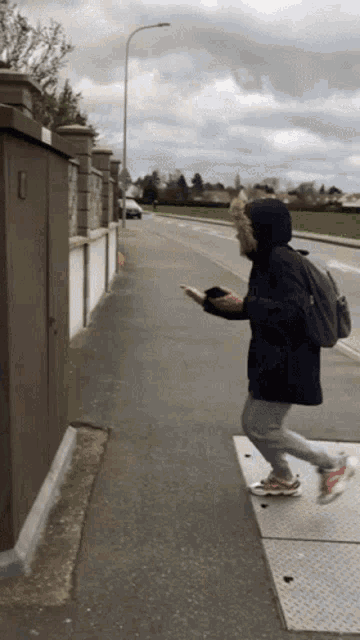 a person with a backpack is walking down a sidewalk