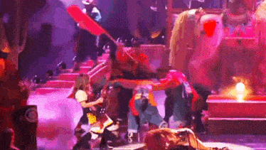 a group of people are playing instruments on a stage while a lion is laying on the ground .