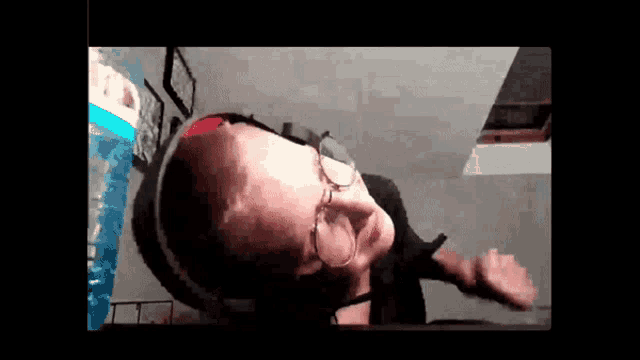 a man wearing glasses and headphones is dancing in a video call