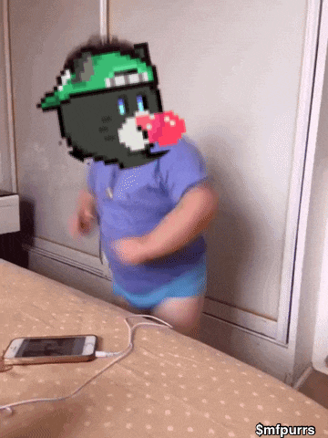 a child with a pixelated cat on his face is standing on a bed next to a cell phone