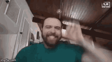 a man with a beard is making a funny face while holding a glass of water in front of his face .