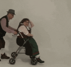 a man pushes an elderly woman in a walker