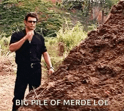 a man is standing next to a pile of dirt and talking .