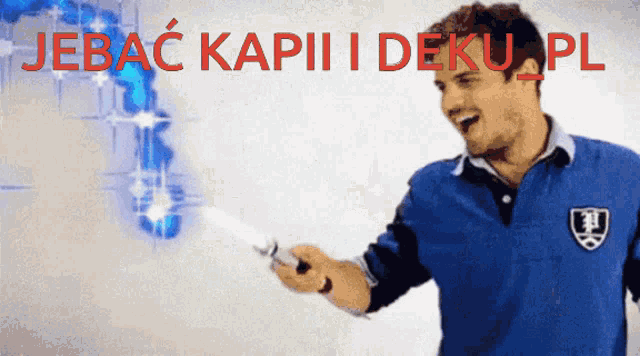 a man in a blue shirt is holding a knife in front of a sign that says jebac kapiii deku pl