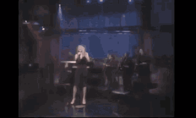 a woman is singing into a microphone on stage