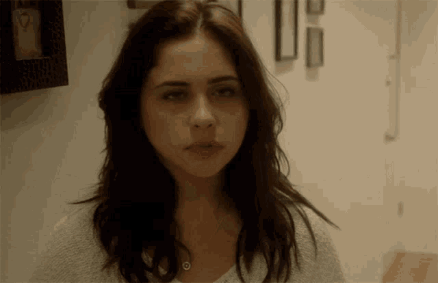 a woman in a hallway with a picture on the wall that says ' i love you ' on it