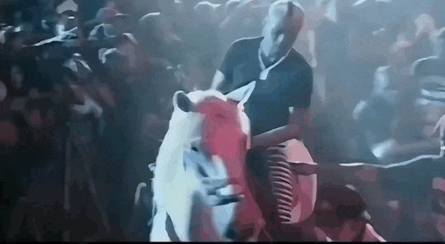 a man is riding a horse in front of a crowd .